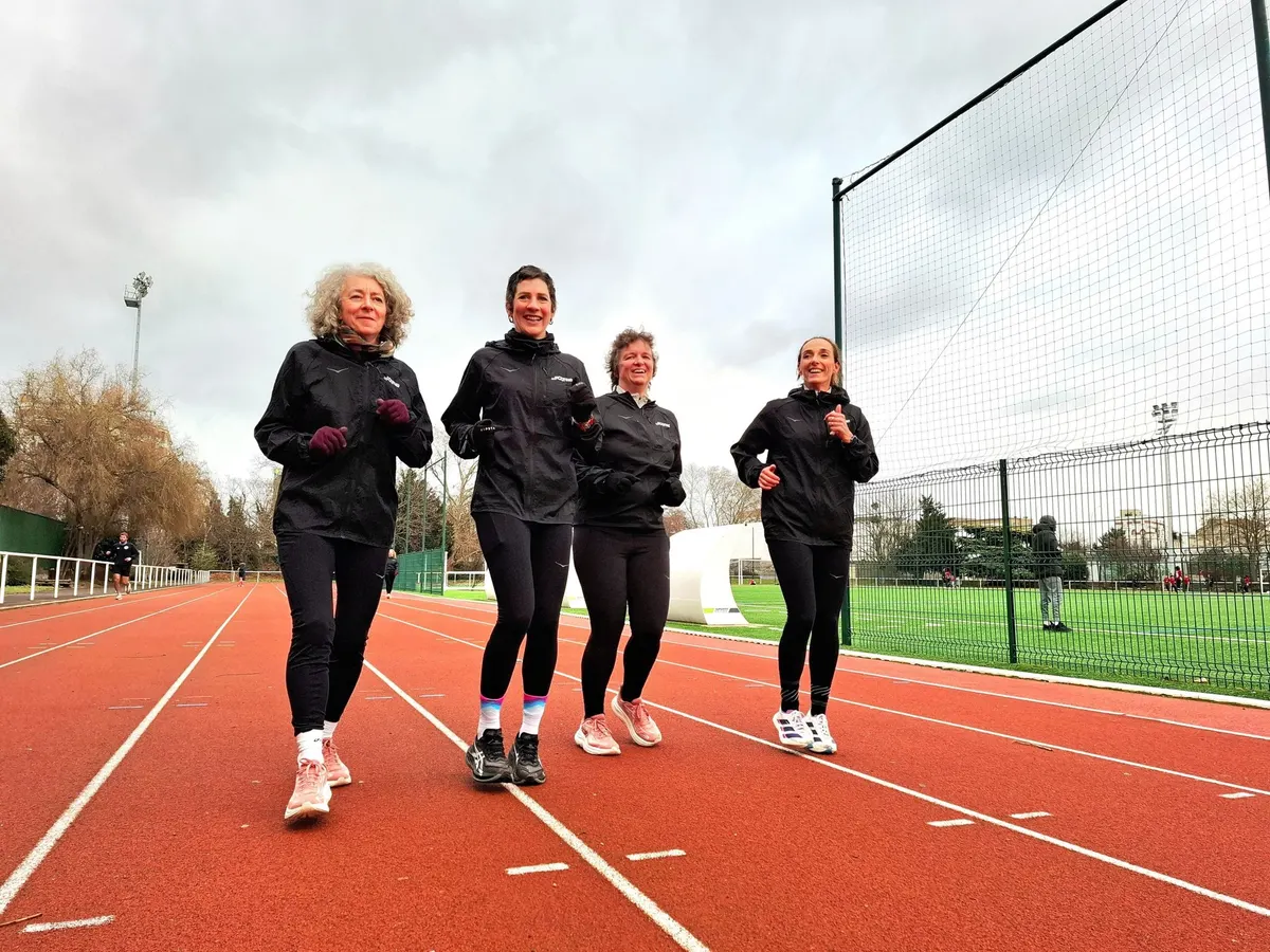 Quatre collaboratrices courent ensemble, sourire aux lèvres, sur une piste d'athlétisme